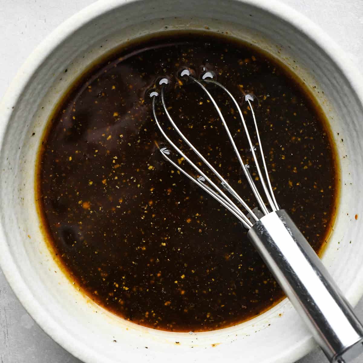 Asian Chicken Lettuce Wraps sauce in a bowl with a whisk