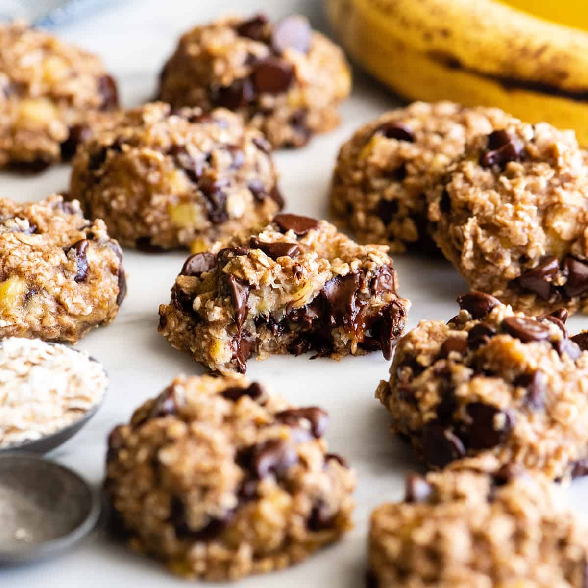 These banana oatmeal cookies are easy to make with a few simple ingredients in 20 minutes. Banana oat cookies are a delicious breakfast, snack or healthy dessert - add chocolate chip or your favorite mix-ins to make them extra-special! front photo of 9 Banana Oatmeal Cookies