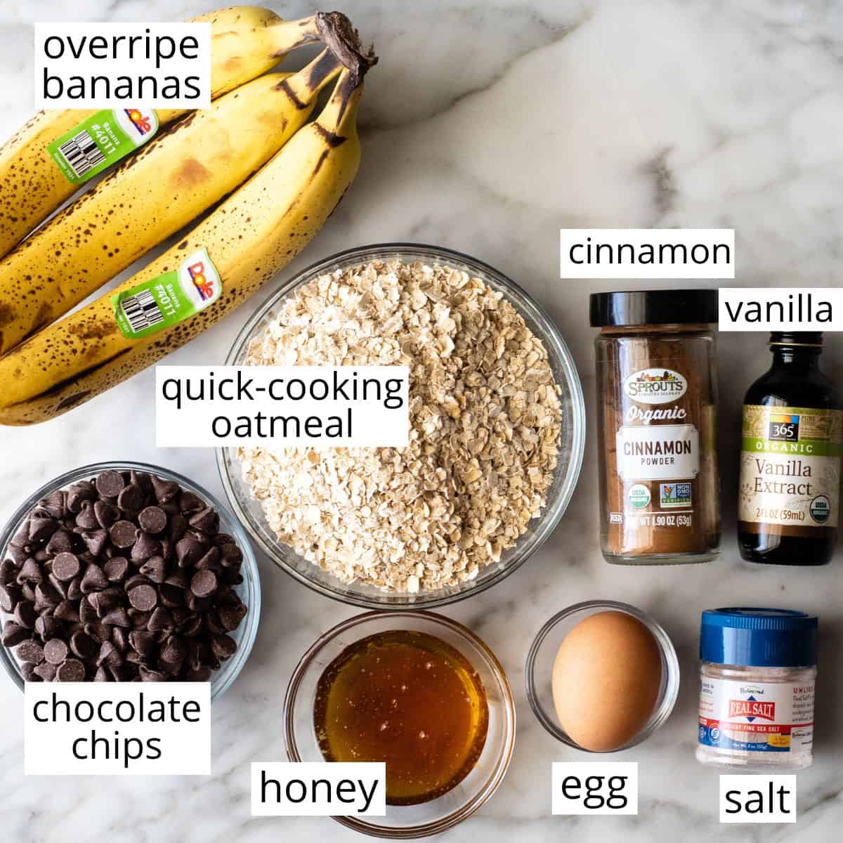 These banana oatmeal cookies are easy to make with a few simple ingredients in 20 minutes. Banana oat cookies are a delicious breakfast, snack or healthy dessert - add chocolate chip or your favorite mix-ins to make them extra-special! overhead photo of the labeled ingredients in this Banana Oatmeal Cookies recipe