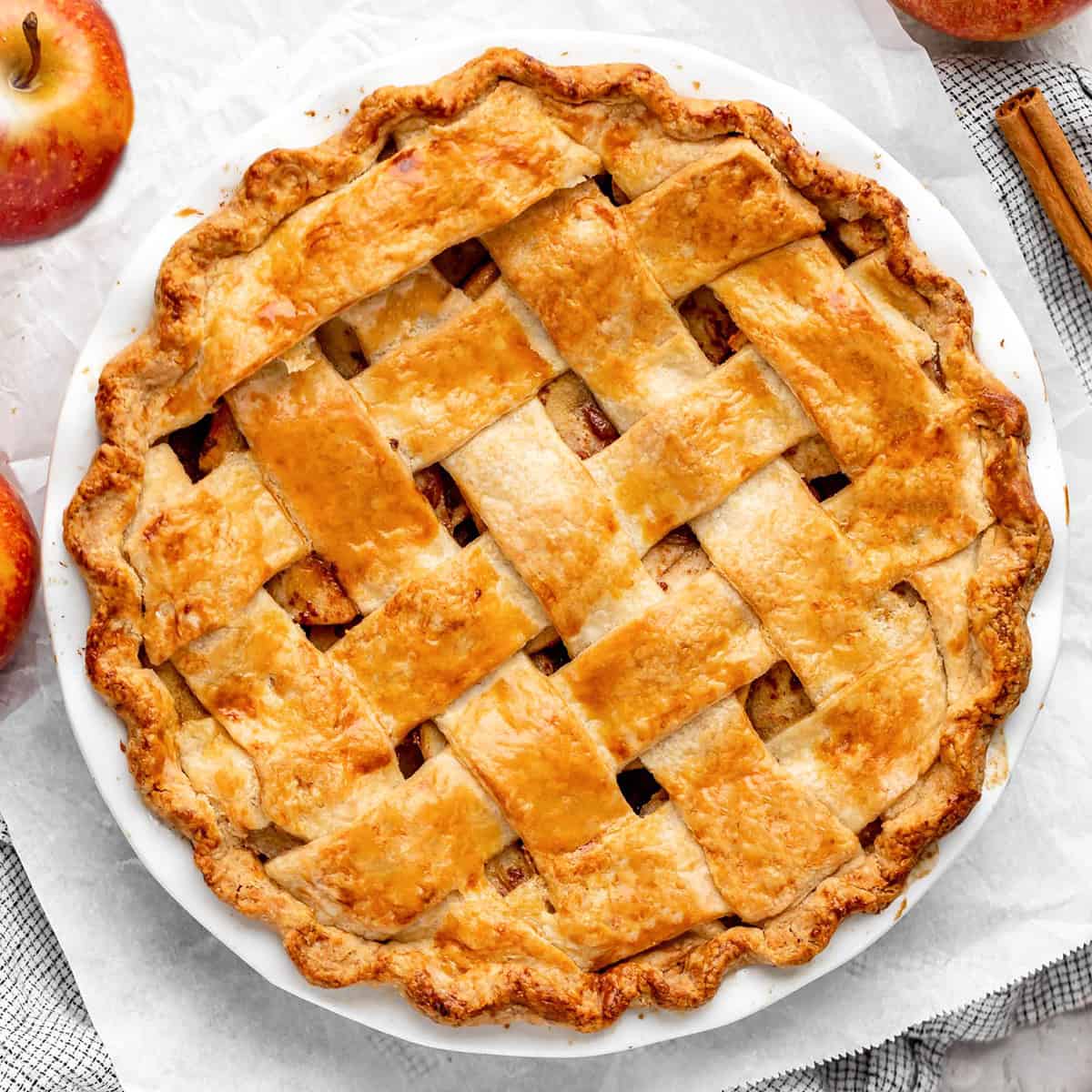 This is truly the best Homemade Apple Pie recipe ever! Its flaky, buttery crust is made from scratch, & the apple filling isn't overly sweet, letting the flavor of the apples really shine! Plus this apple pie is easy to make, with only a handful of simple ingredients! Serve it warm with vanilla ice cream and you will be in dessert heaven! #applepie #pie #homemadeapplepie #applepiecrust #applepiefilling #apples #fall #baking baked apple pie in a pie dish with a lattice crust
