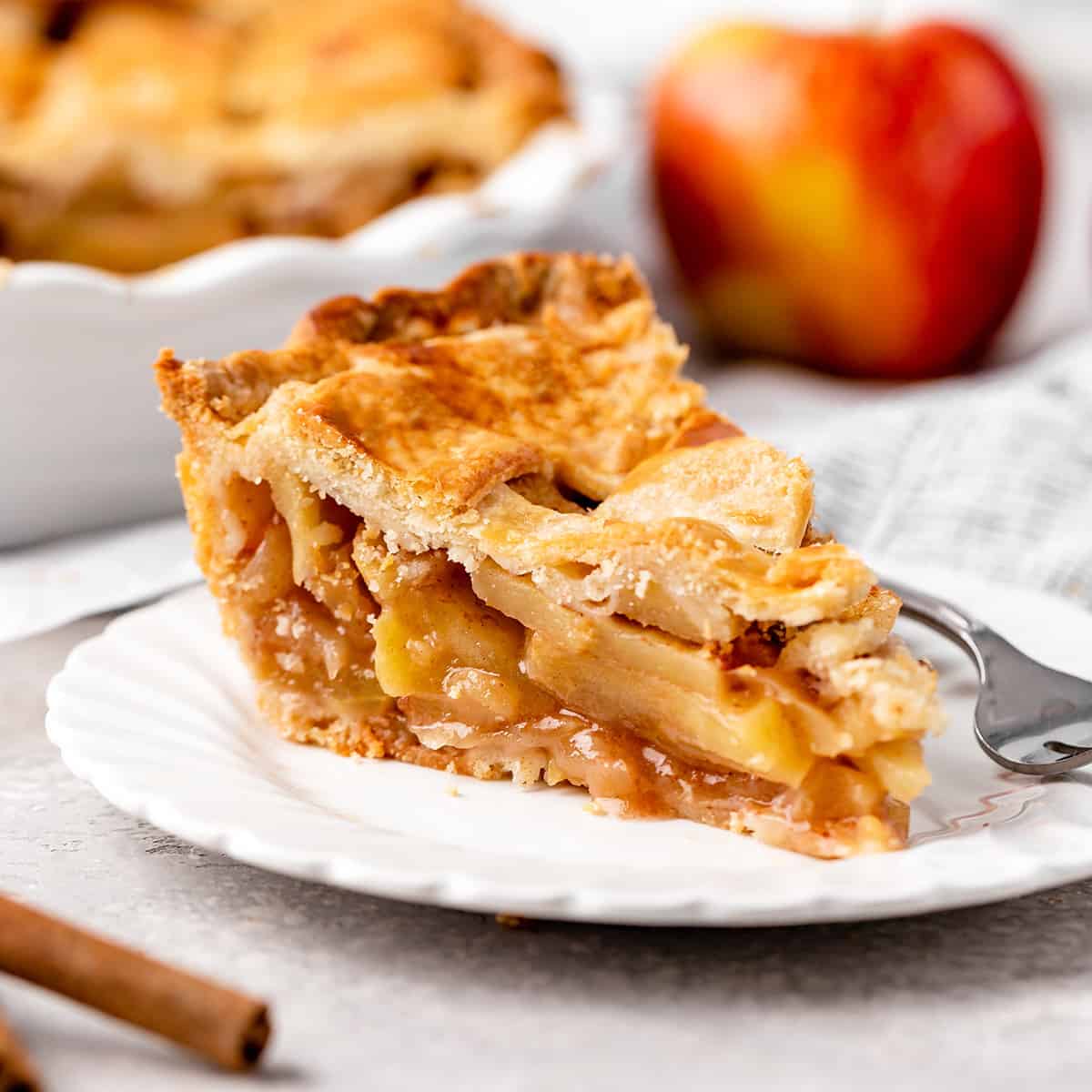 This is truly the best Homemade Apple Pie recipe ever! Its flaky, buttery crust is made from scratch, & the apple filling isn't overly sweet, letting the flavor of the apples really shine! Plus this apple pie is easy to make, with only a handful of simple ingredients! Serve it warm with vanilla ice cream and you will be in dessert heaven! #applepie #pie #homemadeapplepie #applepiecrust #applepiefilling #apples #fall #baking a slice of apple pie on a plate with a fork