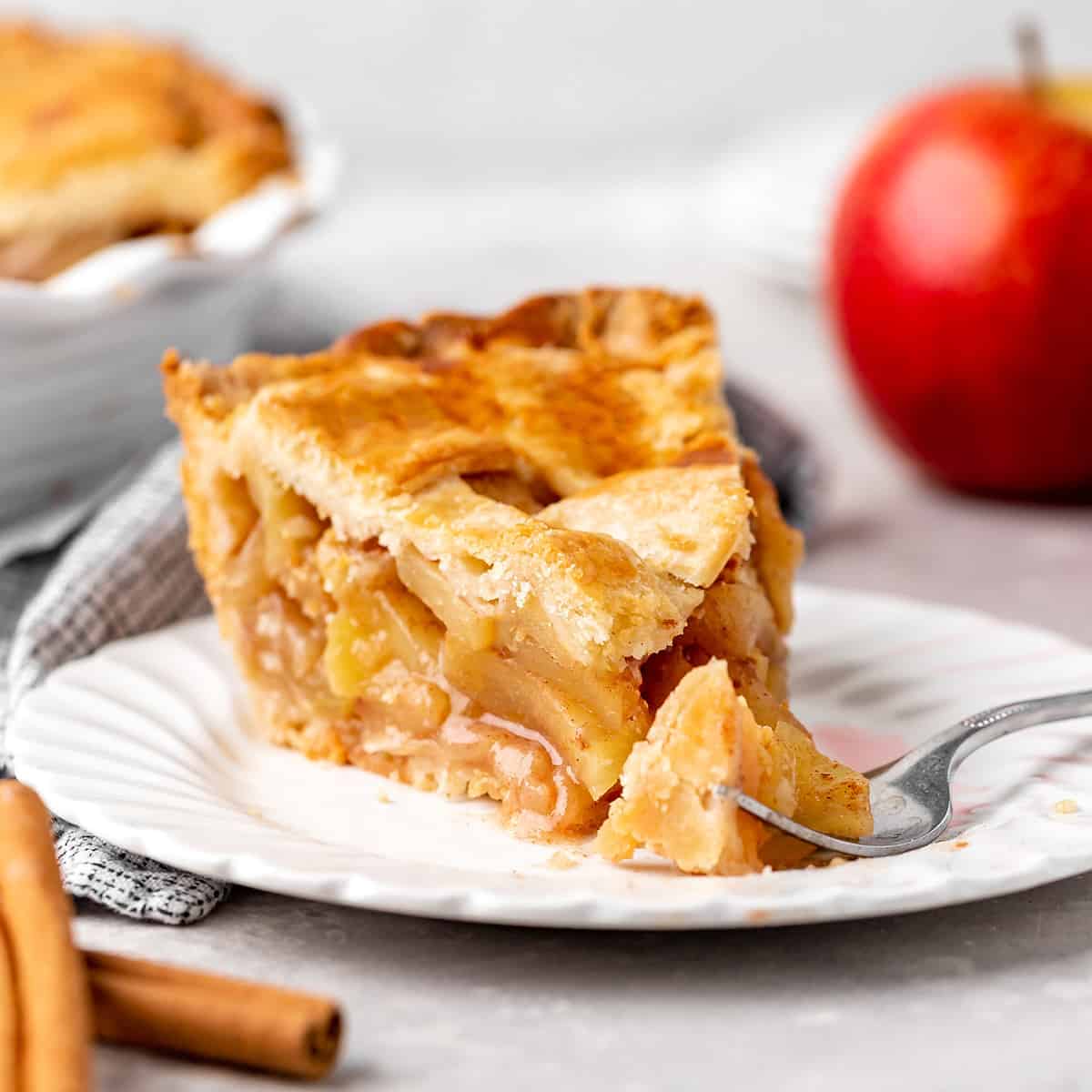 a slice of apple pie on a plate with a fork