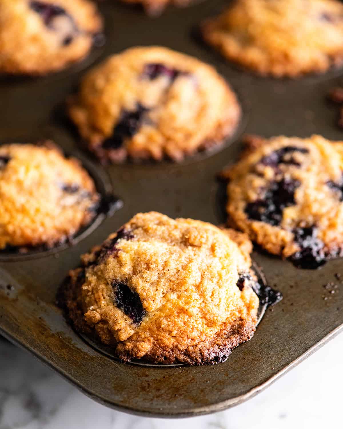 front view of blueberry muffins in a muffin tin after baking