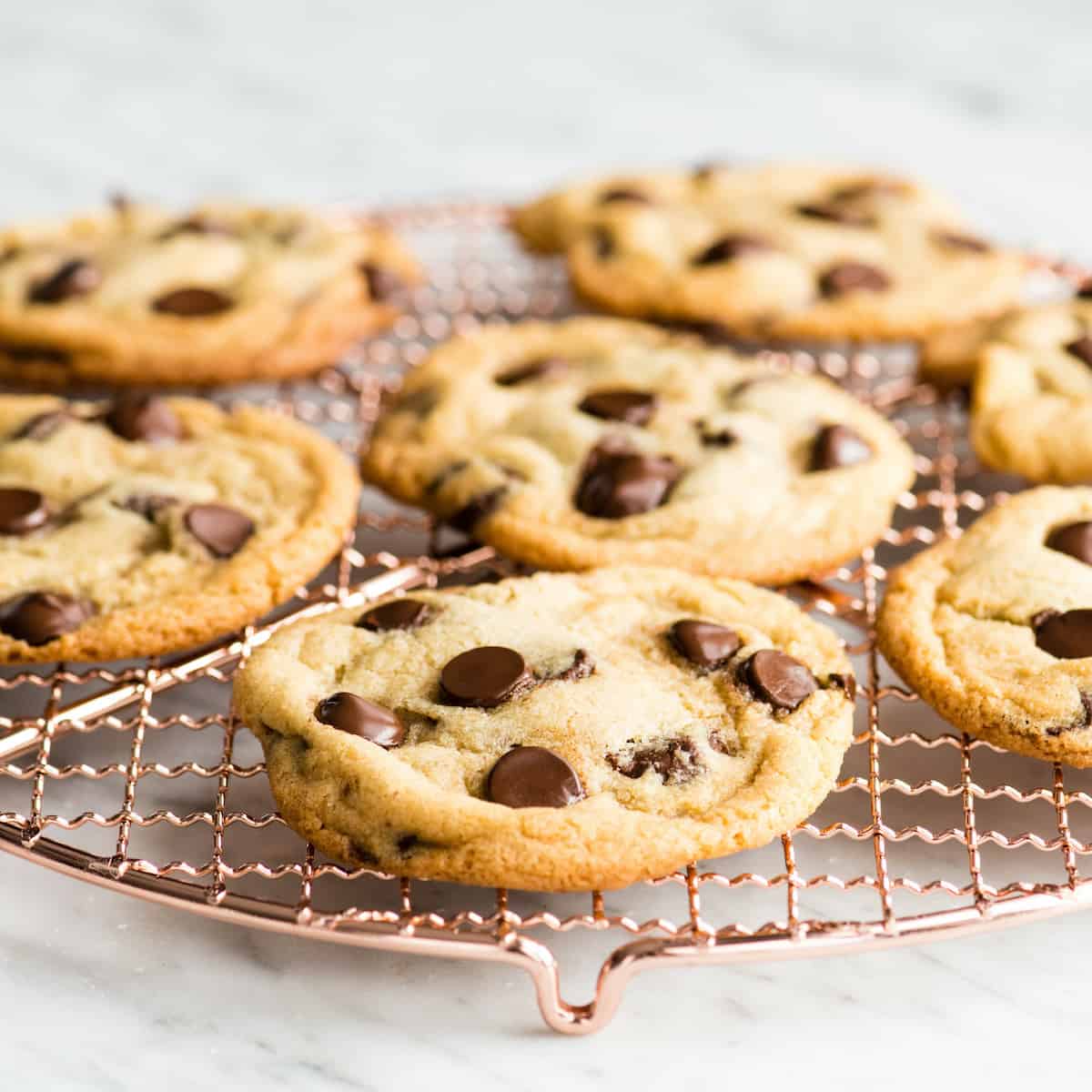front view of chocolate chip cookies cooling on a copper wire cooling rack
