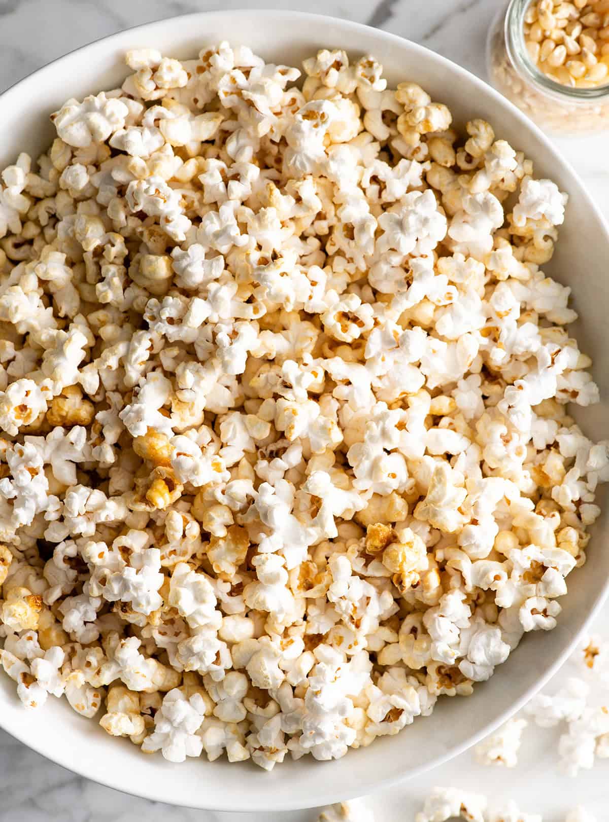 This easy homemade Kettle Corn Recipe is made with 4 ingredients, in less than 5 minutes on the stovetop. Better than the kettle corn at the fair! It's gluten-free and dairy-free! homemade kettle corn in a white bowl