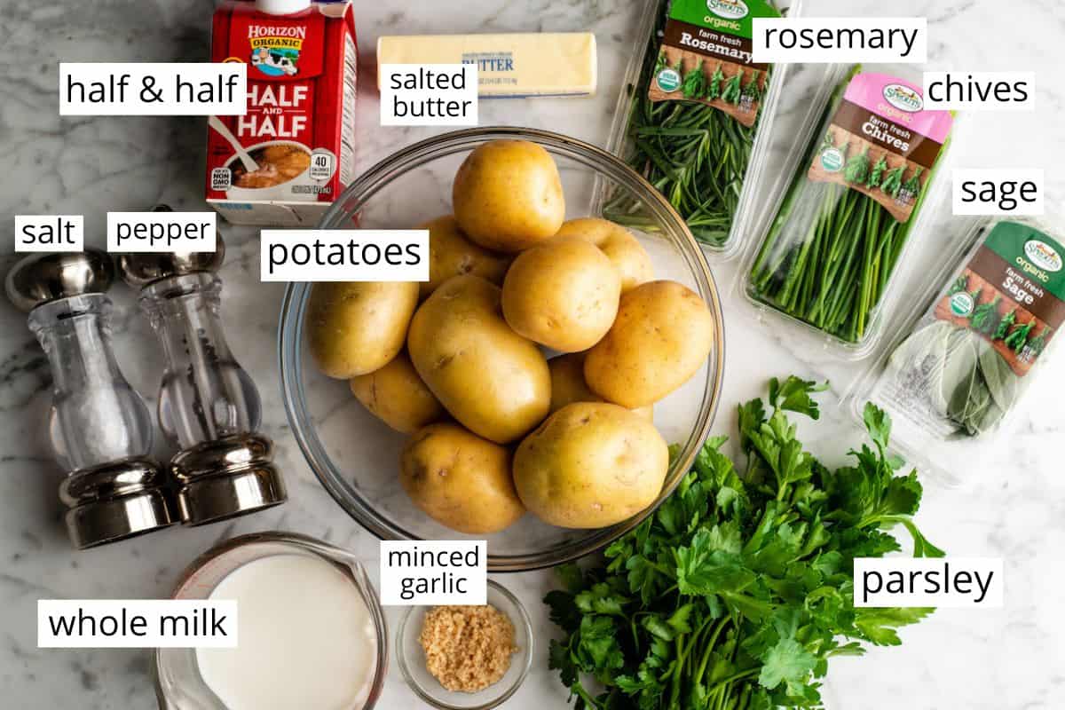 These herb-infused garlic mashed potatoes are the best mashed potatoes you will ever eat. They are creamy, fluffy buttery and so insanely delicious you will never make another mashed potatoes recipe again. Plus they're easy to make and can be prepared ahead of time! overhead photo of the labeled ingredients in this best mashed potatoes recipe