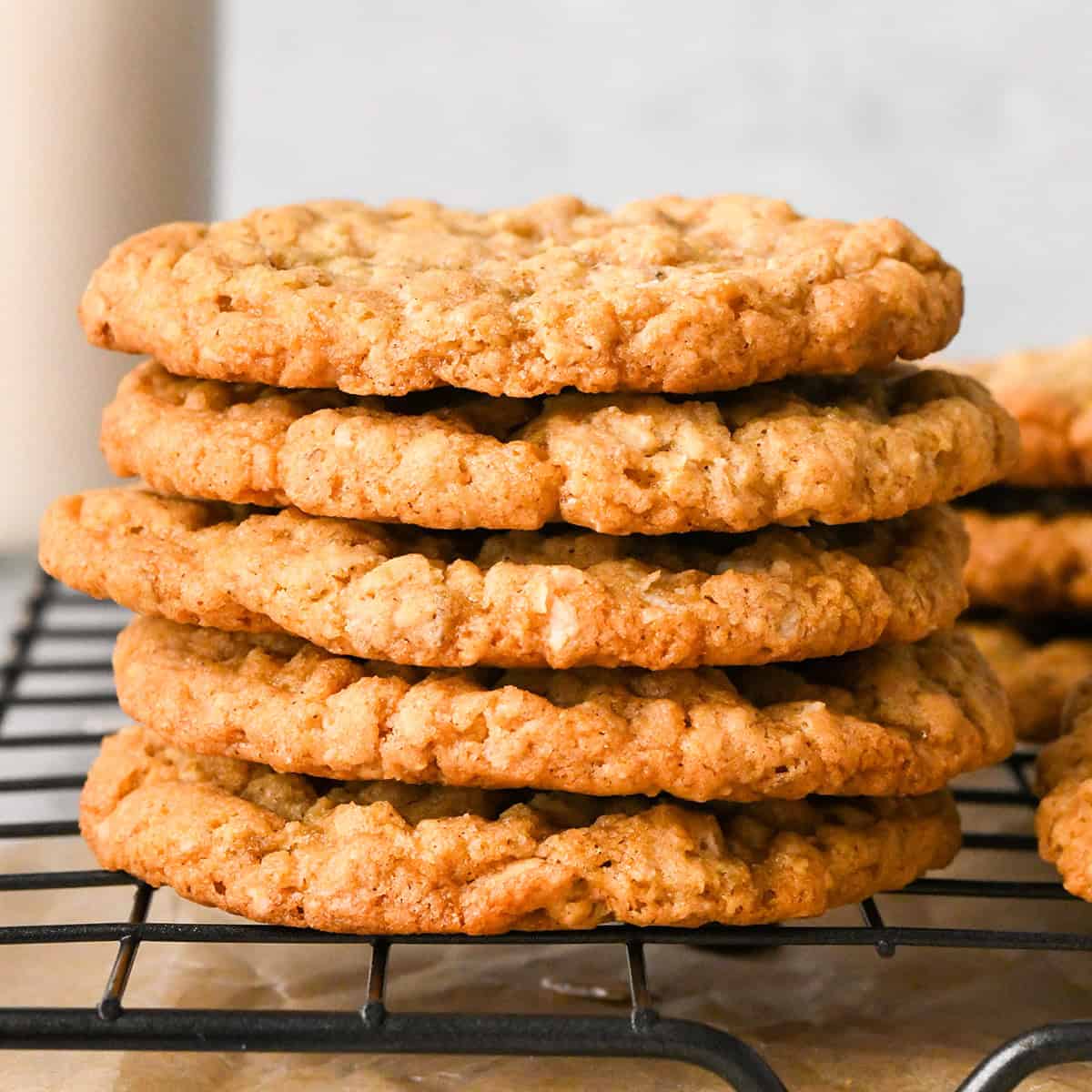 The BEST Oatmeal Cookie Recipe - crispy edges with soft and chewy centers, these oatmeal cookies are easy to make and out-of-this-world delicious. Add your favorite mix-ins for an extra special twist! #oatmealcookies #cookies #baking a stack of five oatmeal cookies on a wire cooling rack