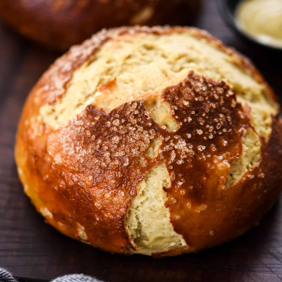 The BEST Homemade Pretzel Bread (or Pretzel Rolls) recipe ever. Seriously, once you make this you will never be able to eat store-bought pretzel bread again! It's dense, soft, chewy, buttery, salty and irresistibly delicious. Front view of a full loaf of homemade pretzel bread