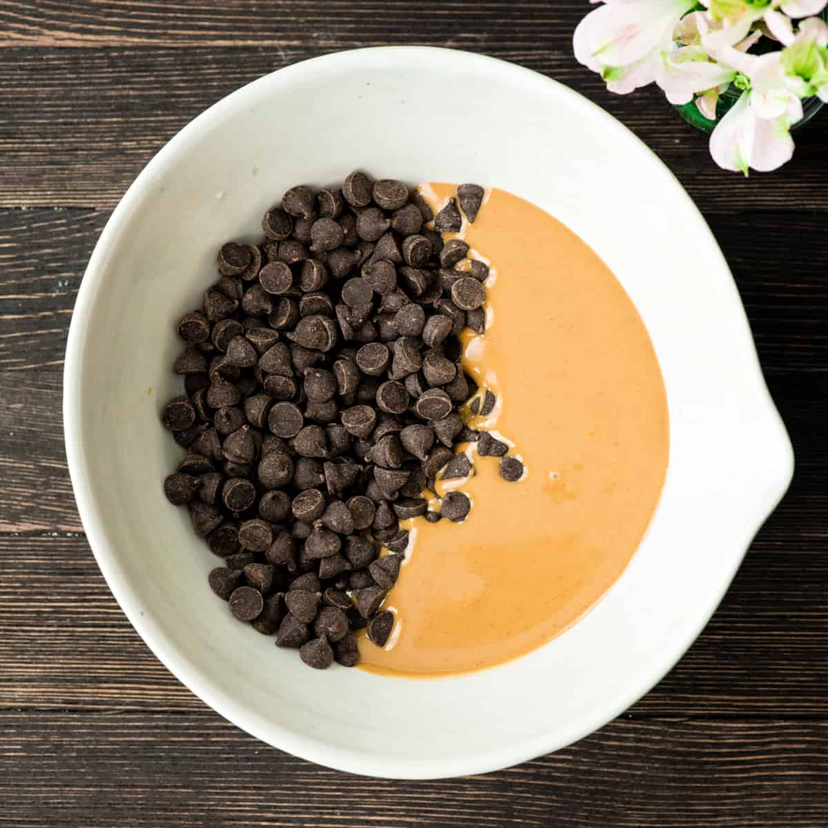 The Best Puppy Chow Recipe (AKA: Muddy Buddies) EVER! Only 4 ingredients (no butter) and a few minutes results in an irresistible dessert loaded with chocolate and peanut butter! The perfect sweet treat to feed a crowd! Overhead photo showing how to make puppy chow - combining peanut butter and chocolate chips