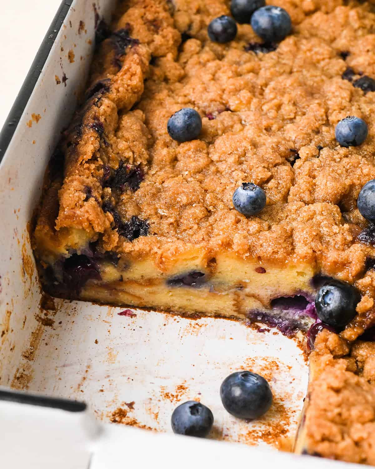Blueberry French Toast Casserole in a baking dish with a piece cut out of it