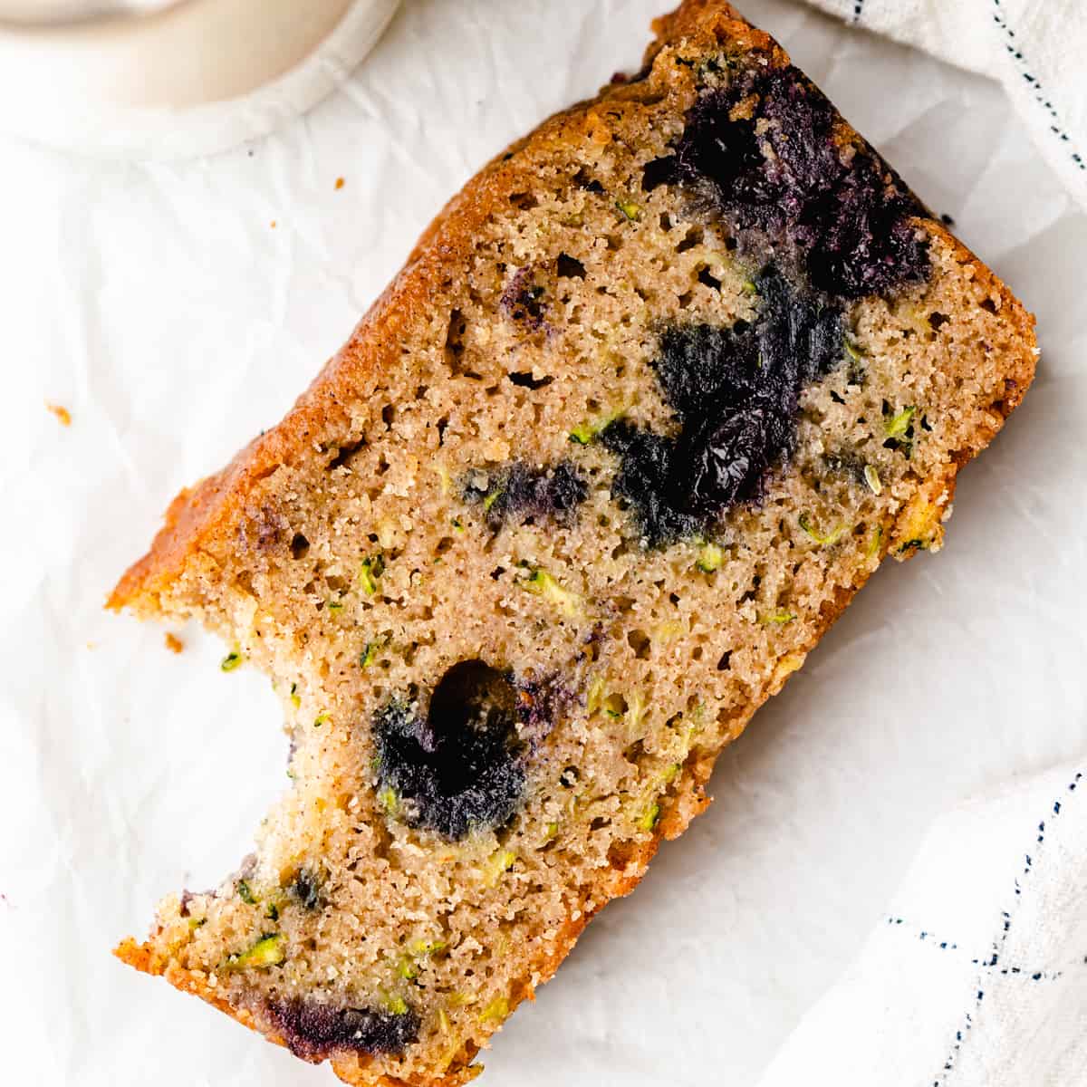 a slice of Blueberry Zucchini Bread with a bite taken out of it