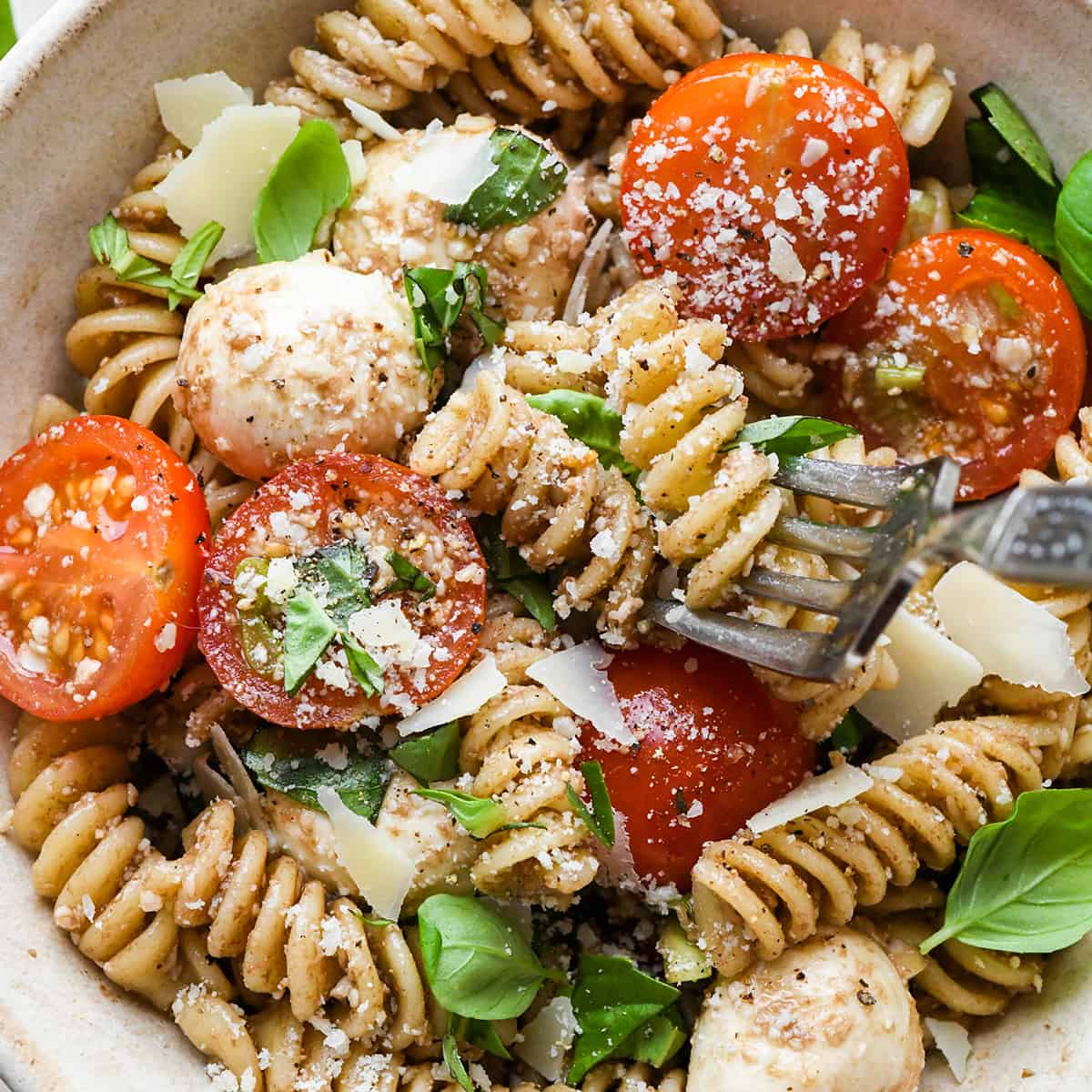 a fork taking a bite of Caprese Pasta Salad