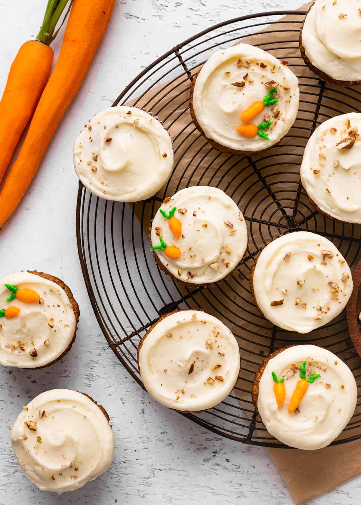10 frosted carrot cake cupcakes on a wire cooling rack