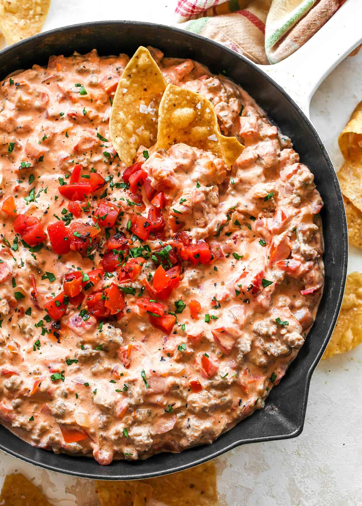 This cream cheese sausage dip is an easy appetizer made with 8 ingredients, in one skillet in 20 minutes. You can easily adjust the spice to make it mild or hot! Serve it with chips, crackers, or veggies for a delicious, low-carb, warm appetizer that will be the hit of any party. overhead view of Cream Cheese Sausage Dip in a skillet