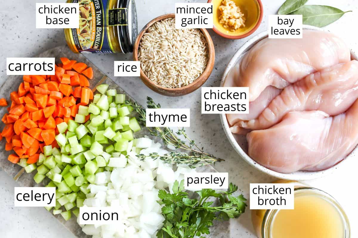 This Chicken and Rice Soup is flavorful, hearty, healthy and it's made in one pot in under an hour! Chicken and wild rice soup is a perfect meal for busy, chilly nights, it makes great leftovers & freezes well too! overhead view of the labeled ingredients in this chicken rice soup recipe