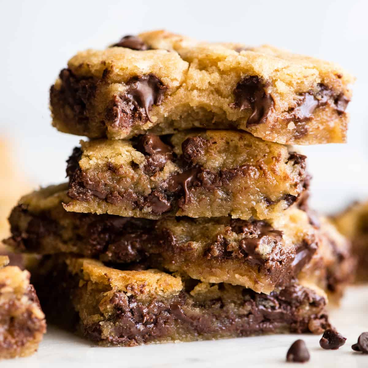 stack of 4 Chocolate Chip Cookie Bars - the top one has a bite taken out of it.