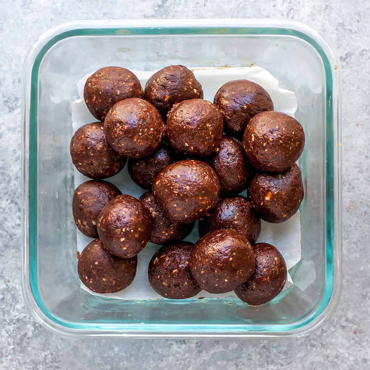 No-Bake Chocolate Date Energy Balls Recipe! These healthy energy balls are made in 5 minutes with 8 ingredients and they taste brownie bites! They are vegan, Paleo gluten-free and have no refined sugar, but you'd never know it! They're also freezer-friendly! #energyballs #energybites #vegan #paleo #snack #glutenfree #joyfoodsunshine overhead view of date energy balls in a glass container