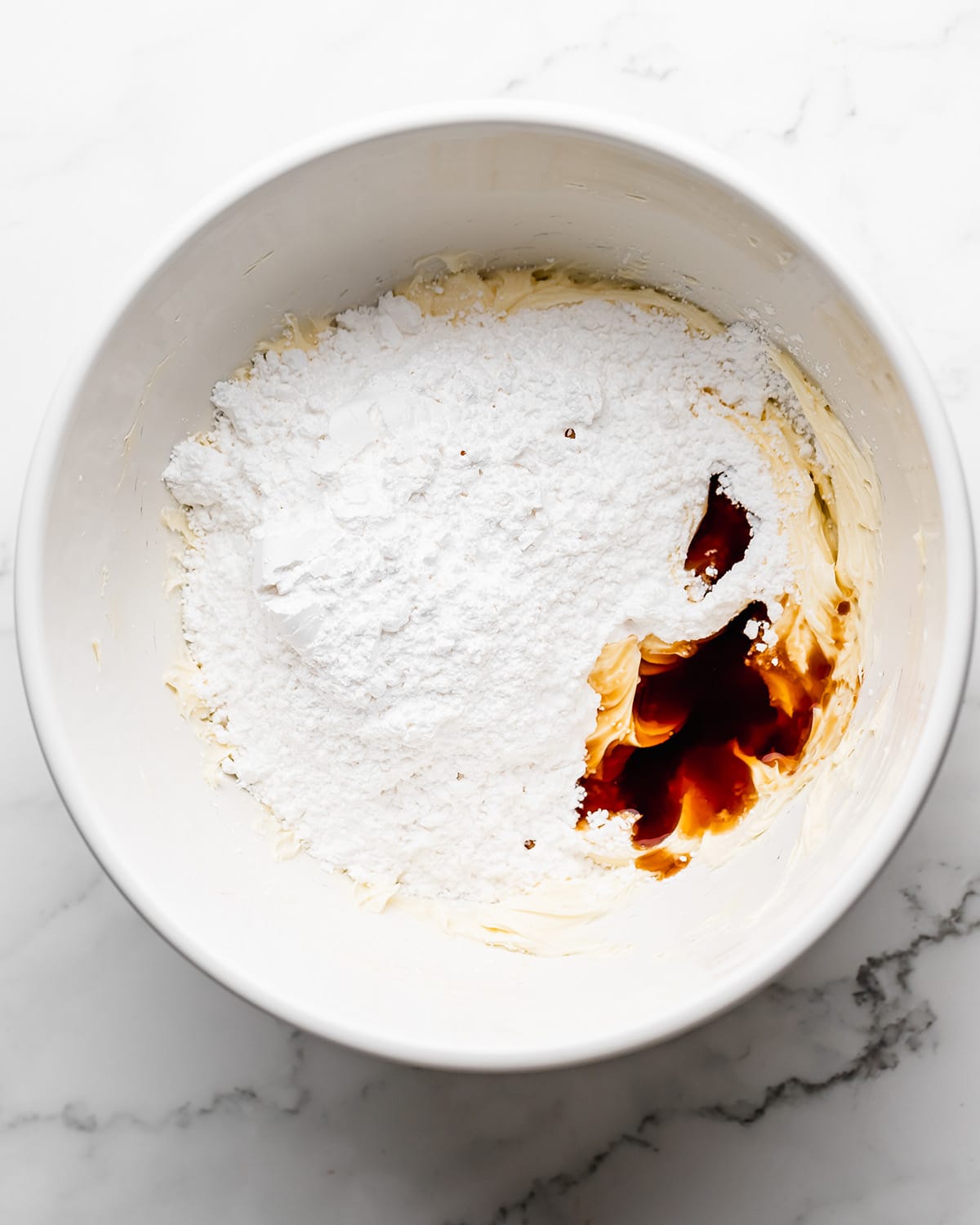 making Coconut Frosting - adding powdered sugar and vanilla before mixing