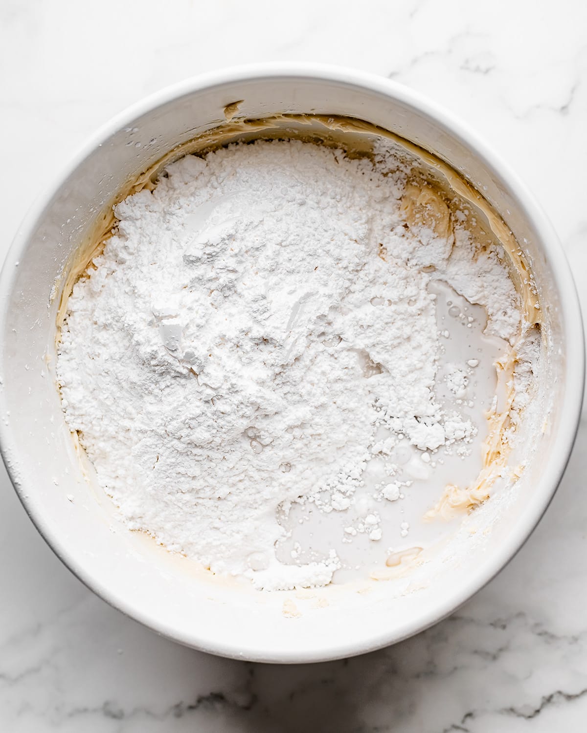 making Coconut Frosting - adding more powdered sugar and coconut milk before mixing