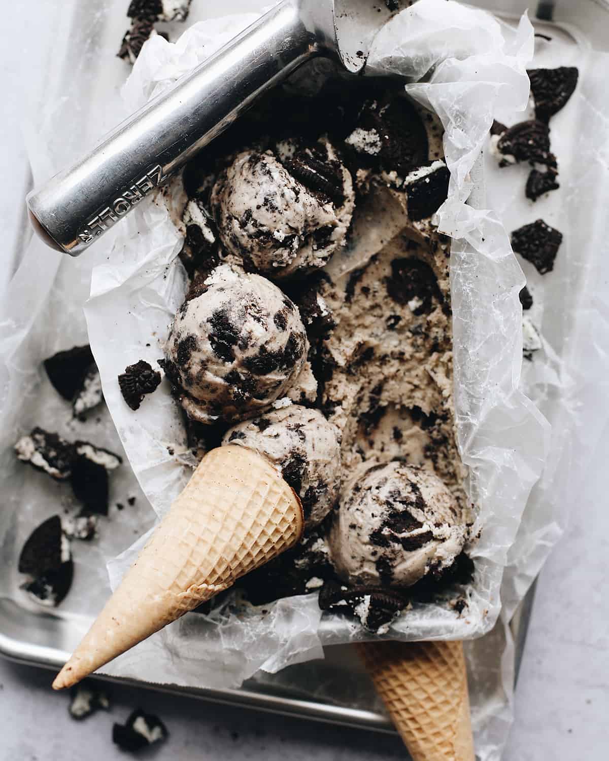 The best cookies and cream ice cream recipe! A creamy Oreo ice cream is loaded with crushed and chopped cookies for a big cookie flavor in every bite! overhead view of scoops of Cookies and Cream Ice Cream