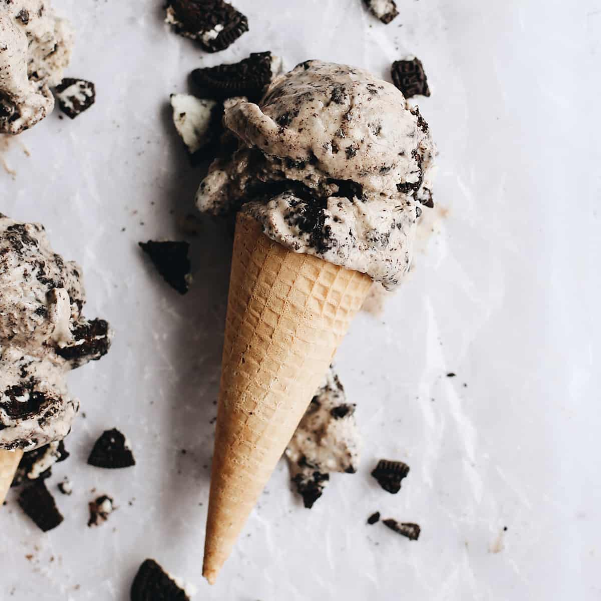 The best cookies and cream ice cream recipe! A creamy Oreo ice cream is loaded with crushed and chopped cookies for a big cookie flavor in every bite! overhead photo of a cone with two scoops of Cookies and Cream Ice Cream (Oreo Ice Cream)