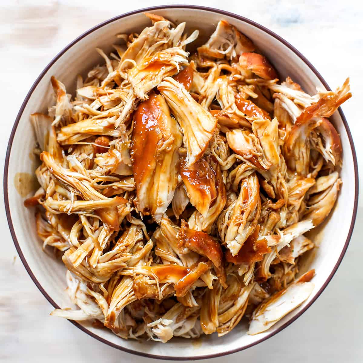 This Crockpot Teriyaki Chicken recipe is an easy recipe perfect for busy weeknights! It only takes 5 minutes to mix together, and then put it in the slow cooker to let it cook. Serve with stir-fried veggies and rice and you have a delicious and healthy meal the whole family will love! overhead photo of crockpot teriyaki chicken in a bowl