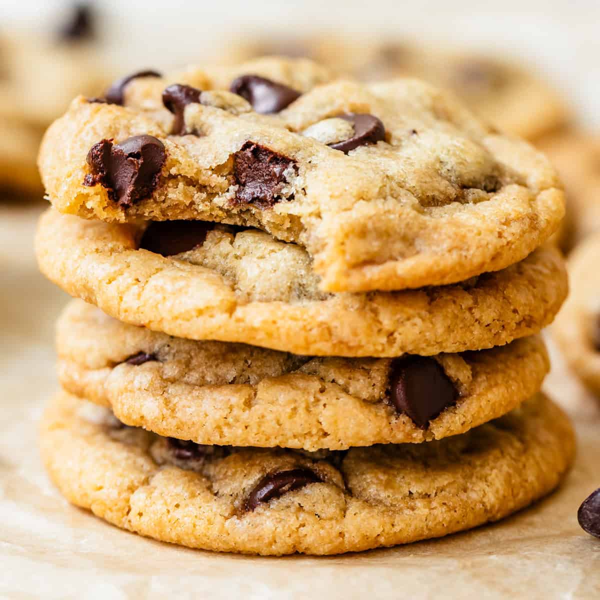 a stack of 4 Dairy Free Chocolate Chip Cookies, the top one has a bite taken out of it