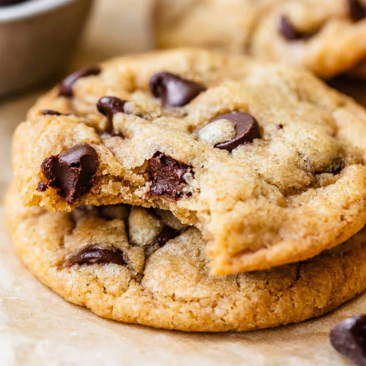 a stack of 2 Dairy Free Chocolate Chip Cookies, the top one has a bite taken out of it