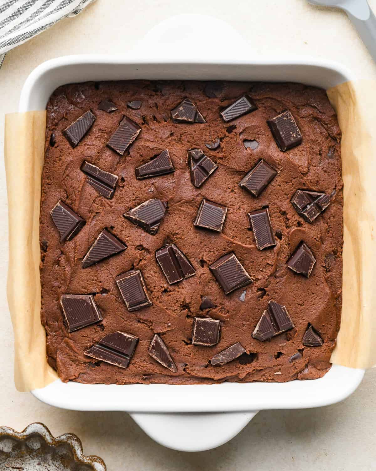 chocolate cookie bars before baking with chopped chocolate pressed into the top