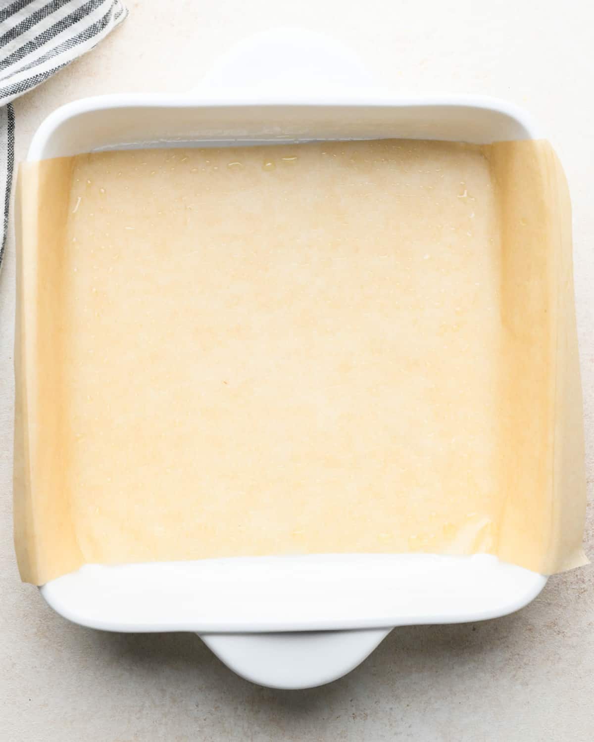 an 8x8" white baking dish lined with parchment paper and lightly greased