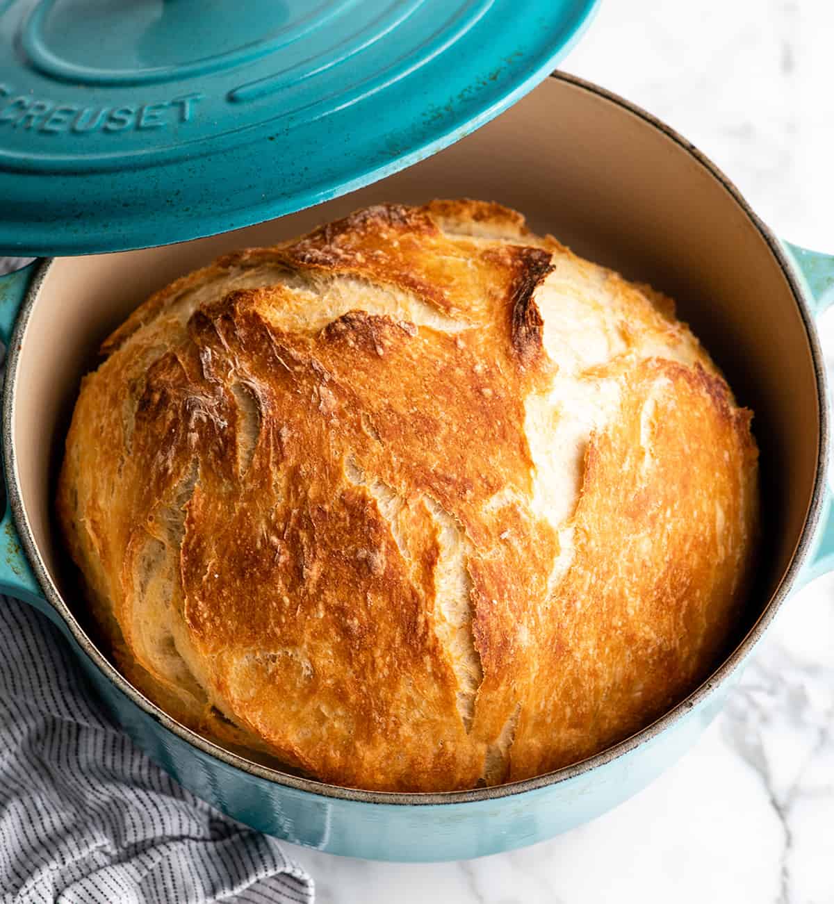 overhead view of baked dutch oven bread in a blue dutch oven