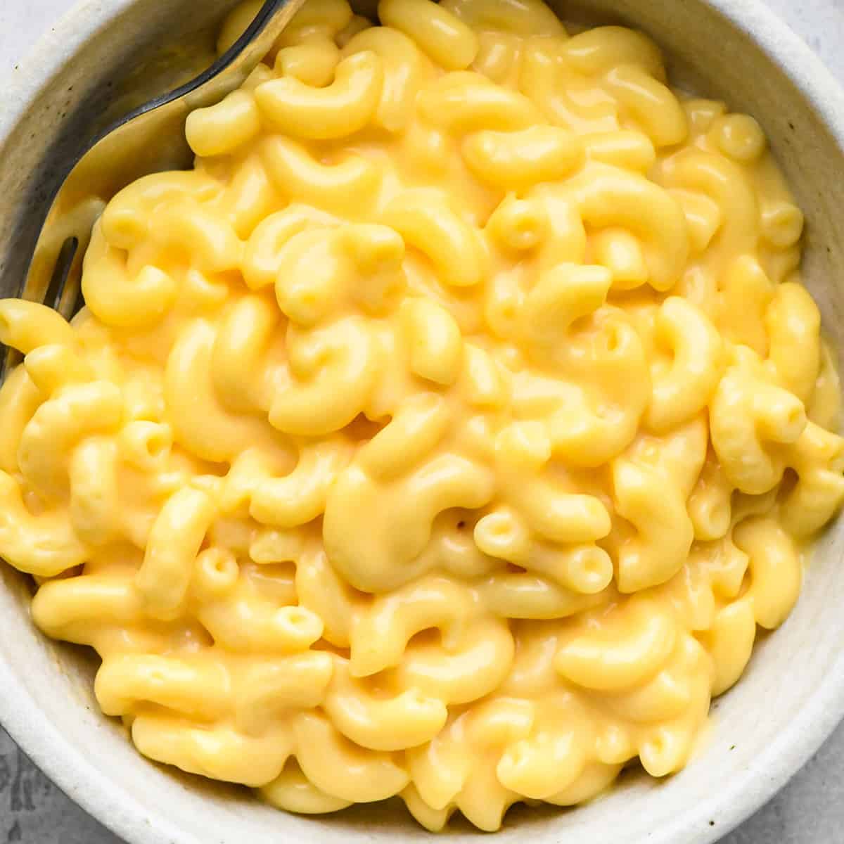This Easy Homemade Mac and Cheese Recipe is made with 6 ingredients in 15 minutes on the stovetop (no baking required)! Time to ditch the boxed mac and cheese for this irresistibly creamy, smooth & cheesy homemade recipe! #homemade #macandcheese #homemademacandcheese #sidedish #maindish #kidfriendly a bowl full of Homemade Mac and Cheese Recipe