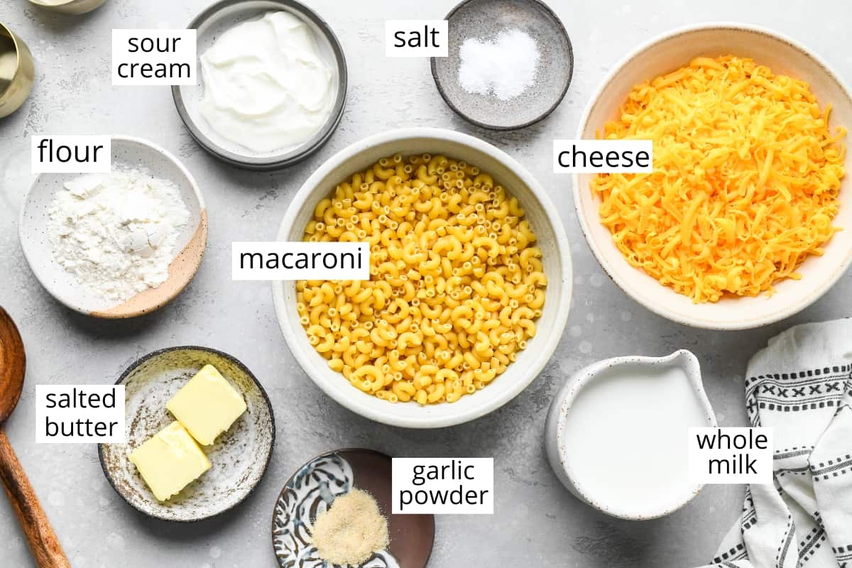This Easy Homemade Mac and Cheese Recipe is made with 8ingredients in 15 minutes on the stovetop (no baking required)! Time to ditch the boxed mac and cheese for this irresistibly creamy, smooth & cheesy homemade recipe! #homemade #macandcheese #homemademacandcheese #sidedish #maindish #kidfriendly overhead photo of the labeled ingredients in this Homemade Mac and Cheese Recipe