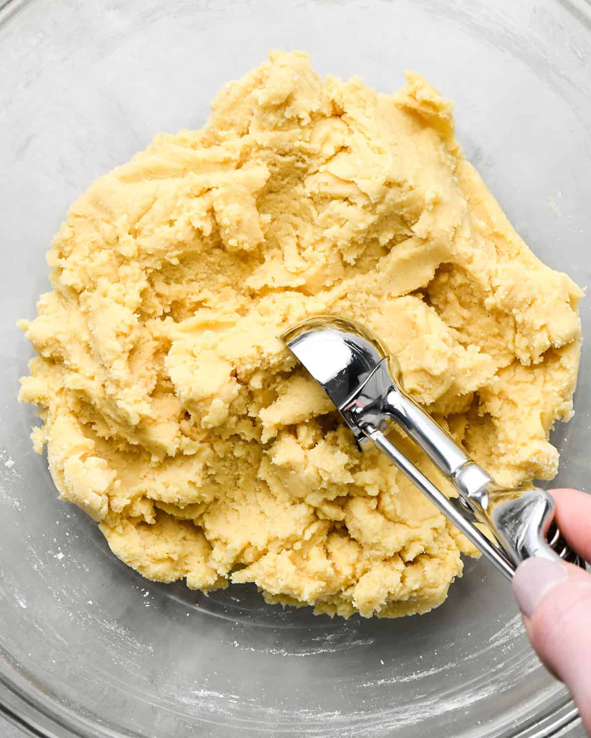 How to Make Easy Sugar Cookies - a cookie scoop measuring out a portion of dough