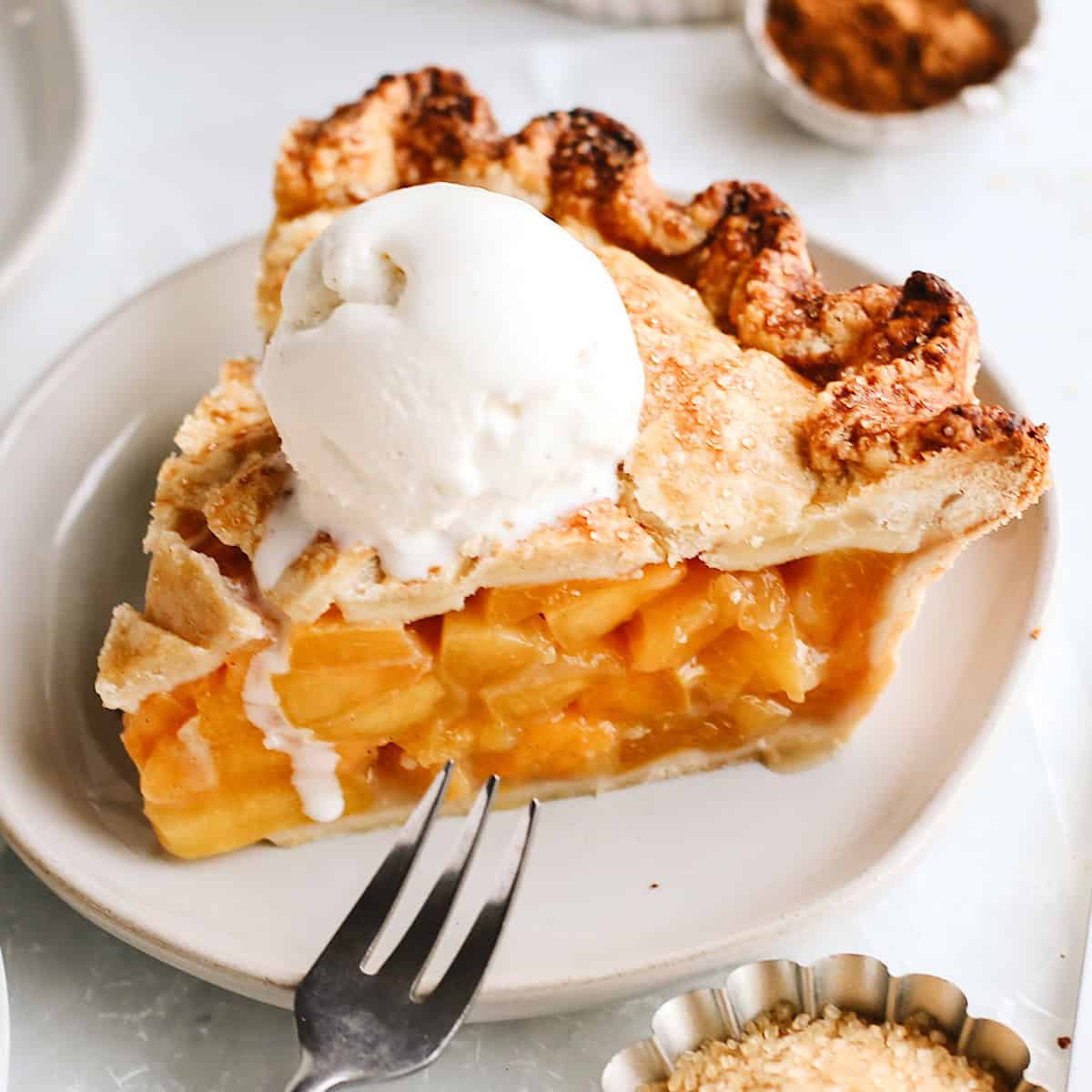 a slice of peach pie with vanilla ice cream on top