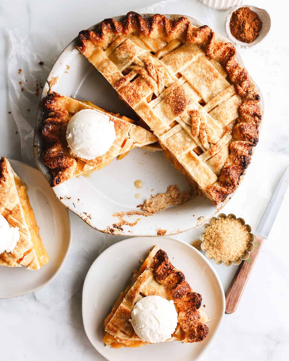 a peach pie with a slice cut out and ice cream on top of the slice.