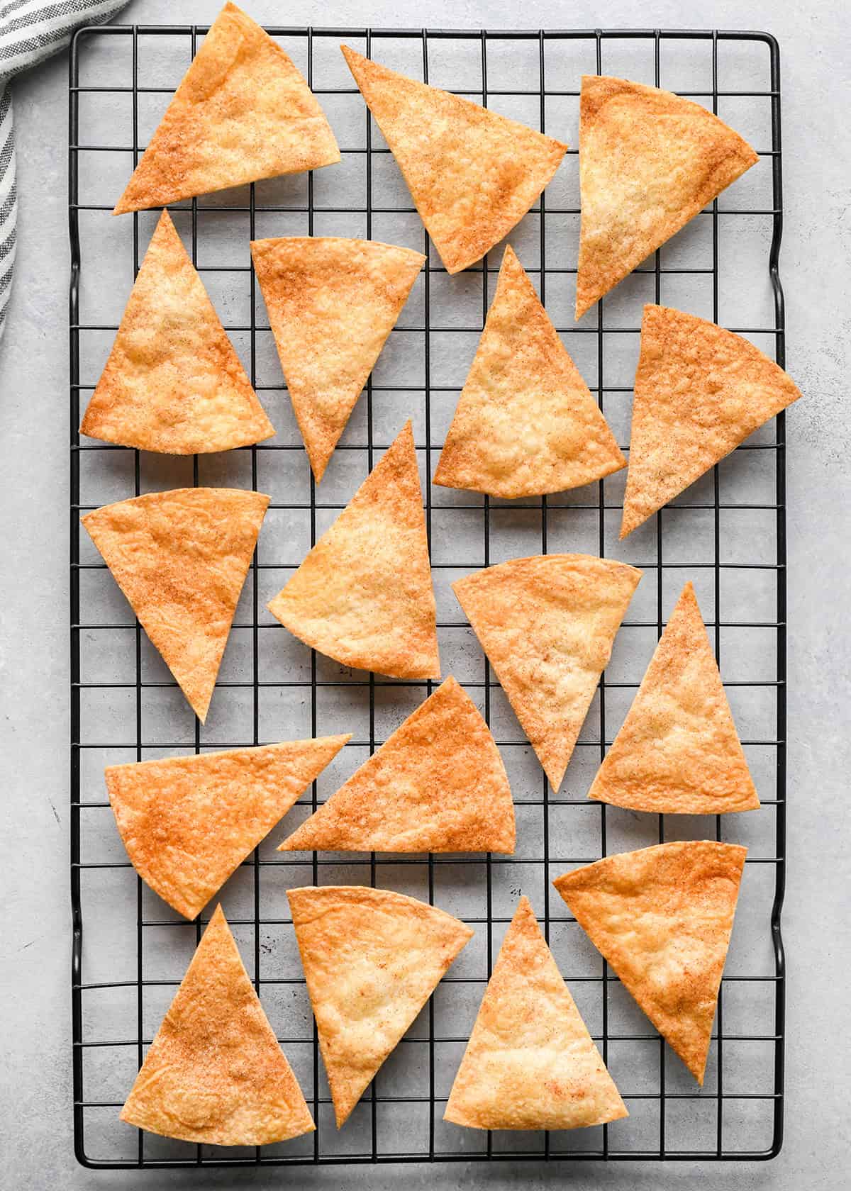 16 cinnamon tortilla chips on a wire cooling rack after baking