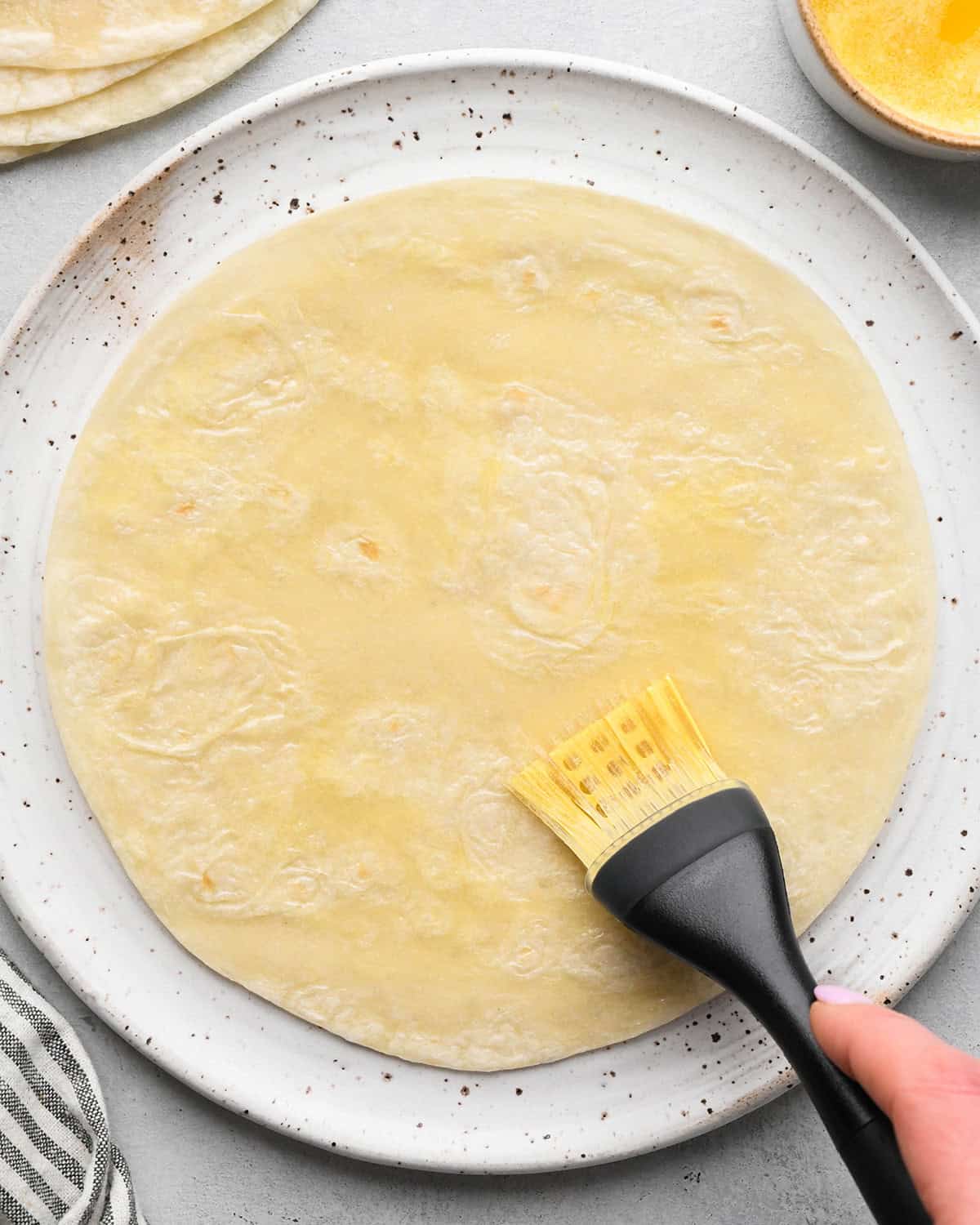 making Fruit Salsa with Cinnamon Chips - brushing butter on a tortilla