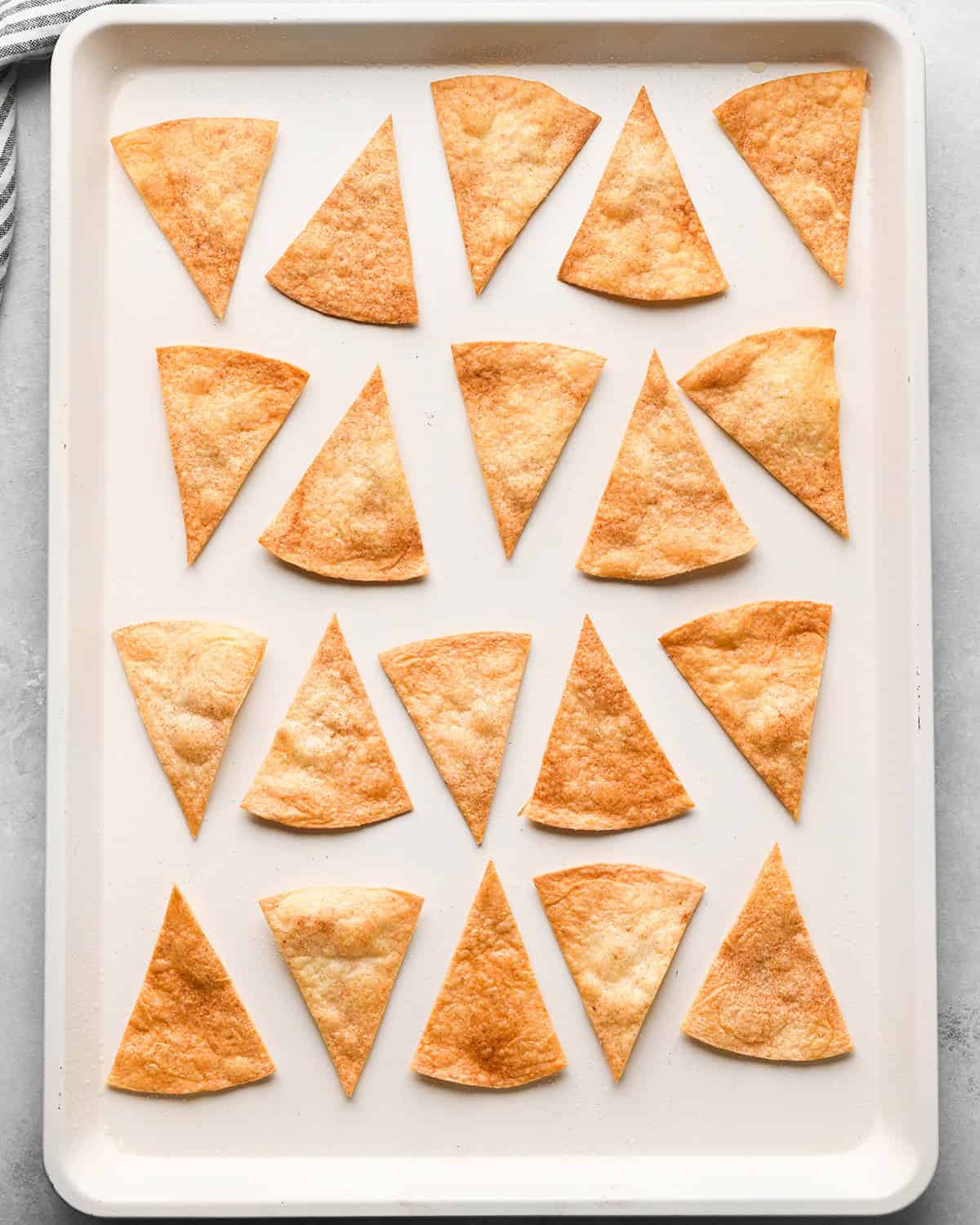 16 cinnamon tortilla chips on a baking pan after making