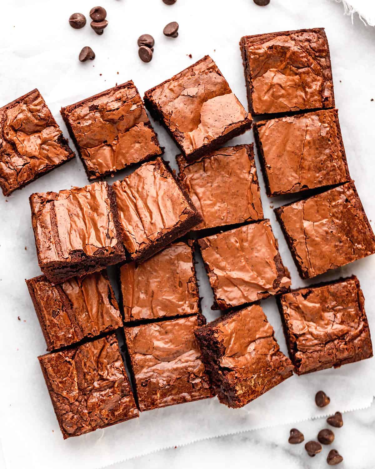 This is the best brownie recipe EVER! These fudgy brownies are homemade from scratch and have a gorgeous crinkly top with a gooey middle! They're easy to make with only 7 ingredients! Ditch the box and make these today! #brownies #brownierecipe #homemadebrownies #fudgybrownies #dessert #browniesfromscratch #baking #dessert #chocolate Overhead view of 16 brownies cut into squares
