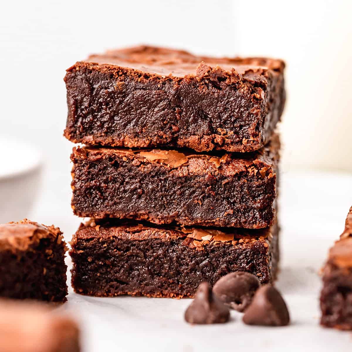 This is the best brownie recipe EVER! These fudgy brownies are homemade from scratch and have a gorgeous crinkly top with a gooey middle! They're easy to make with only 7 ingredients! Ditch the box and make these today! #brownies #brownierecipe #homemadebrownies #fudgybrownies #dessert #browniesfromscratch #baking #dessert #chocolate stack of 3 fudgy brownies