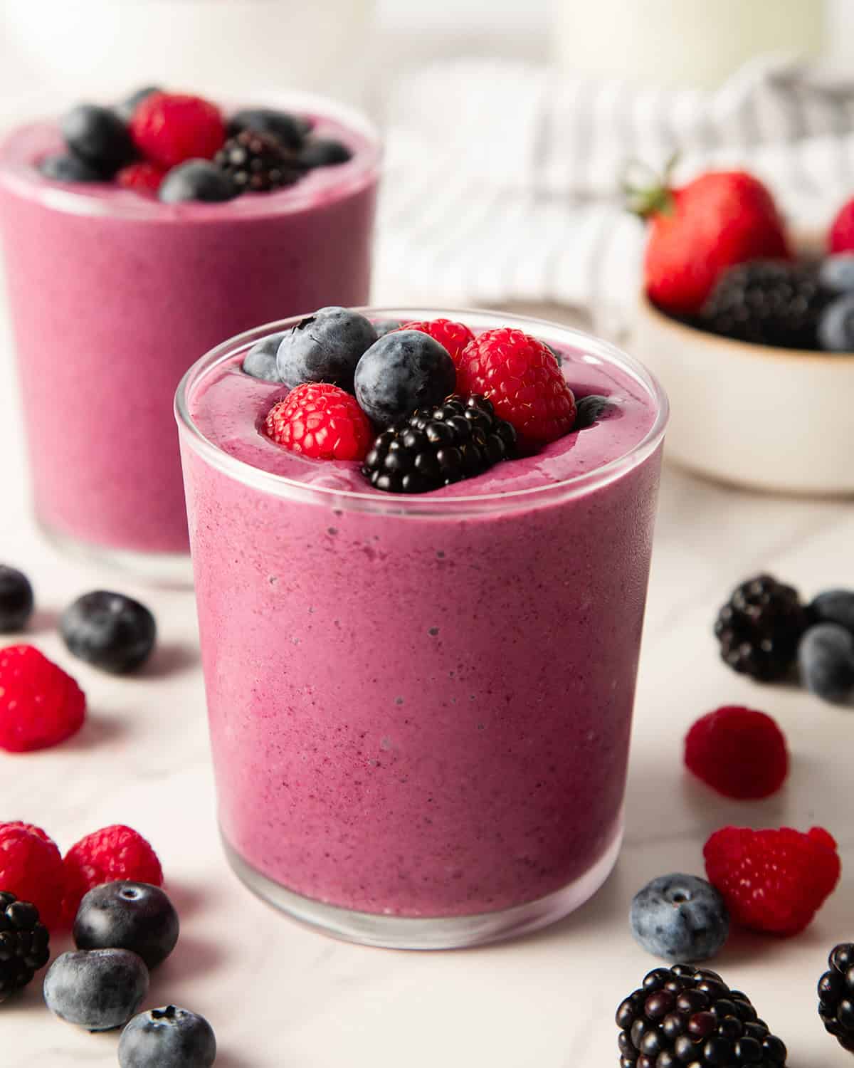 greek yogurt smoothie in a glass cup topped with berries
