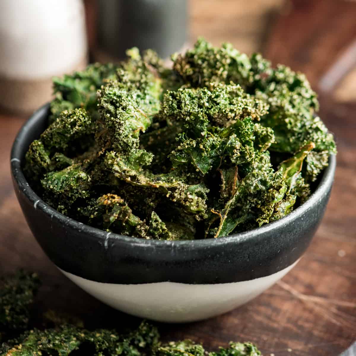 This is the best Baked Kale Chips recipe ever! Homemade crispy kale chips are a delicious, healthy snack made with only five ingredients. Roasting kale chips in the oven keeps them crispy for days! Front view of a bowl of crispy kale chips