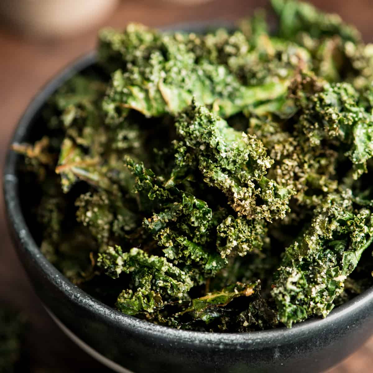 This is the best Baked Kale Chips recipe ever! Homemade crispy kale chips are a delicious, healthy snack made with only five ingredients. Roasting kale chips in the oven keeps them crispy for days! baked kale chips in a bowl
