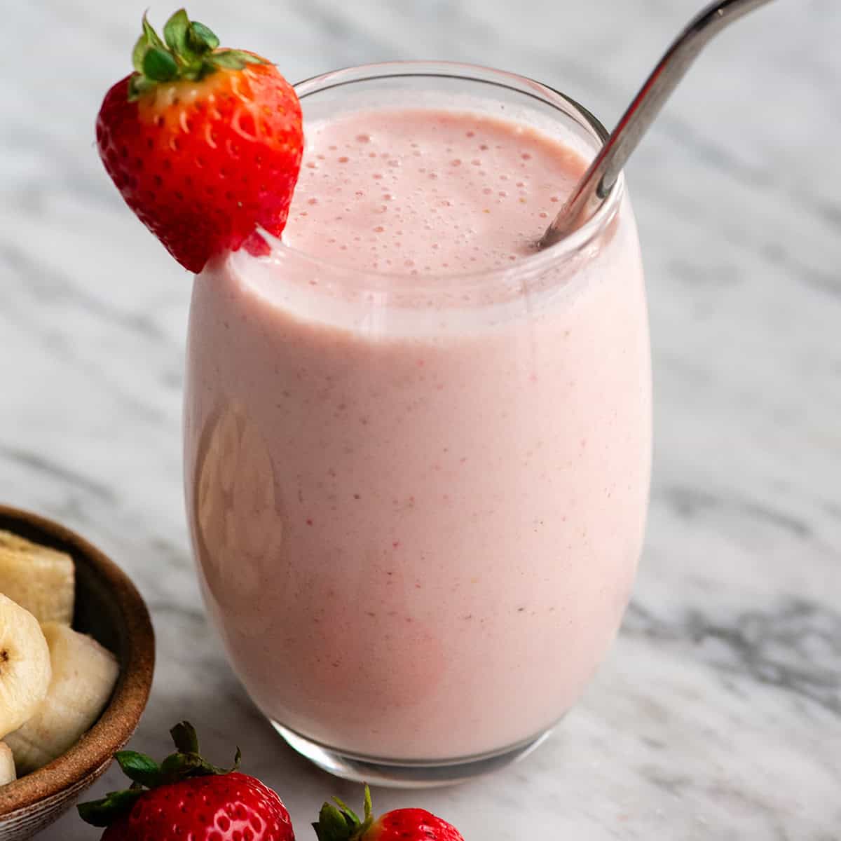 The BEST strawberry banana smoothie recipe ever! It's easy (ready in less than 5 minutes), healthy, and made with yogurt so it's full of protein! It's the perfect snack or breakfast! #smoothie #strawberrybananasmoothie #strawberry #banana #breakfast #snack #vitamix a glass of strawberry banana smoothie with straw