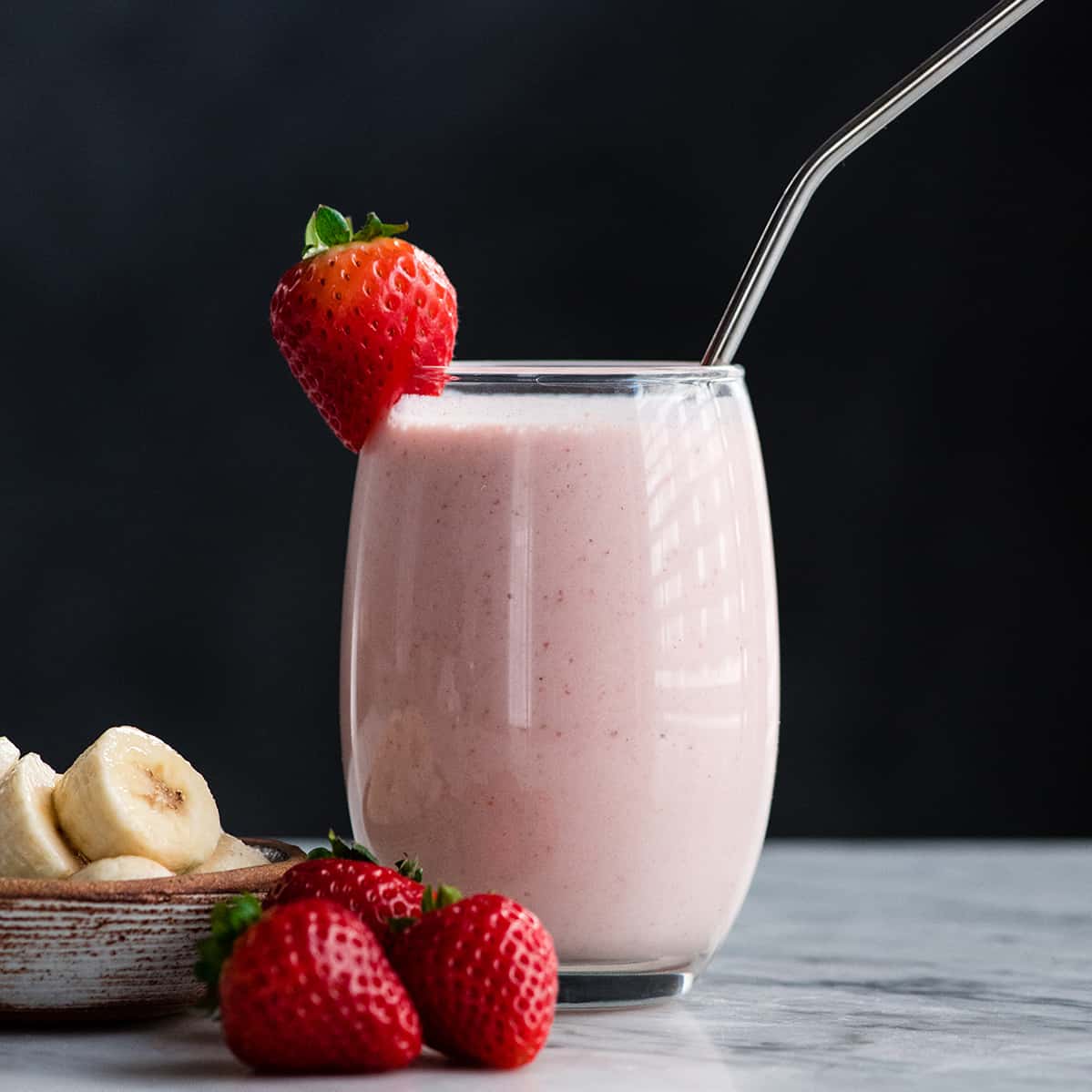 The BEST strawberry banana smoothie recipe ever! It's easy (ready in less than 5 minutes), healthy, and made with yogurt so it's full of protein! It's the perfect snack or breakfast! #smoothie #strawberrybananasmoothie #strawberry #banana #breakfast #snack #vitamix Front view of a glass full of a Strawberry Banana Smoothie