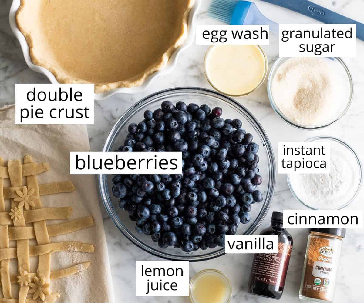 This is the best homemade Blueberry Pie Recipe you'll ever make! It's made from scratch with a fresh blueberry pie filling and NO cornstarch, and includes step-by-step instructions and photos! overhead view of the labeled ingredients in this blueberry pie recipe