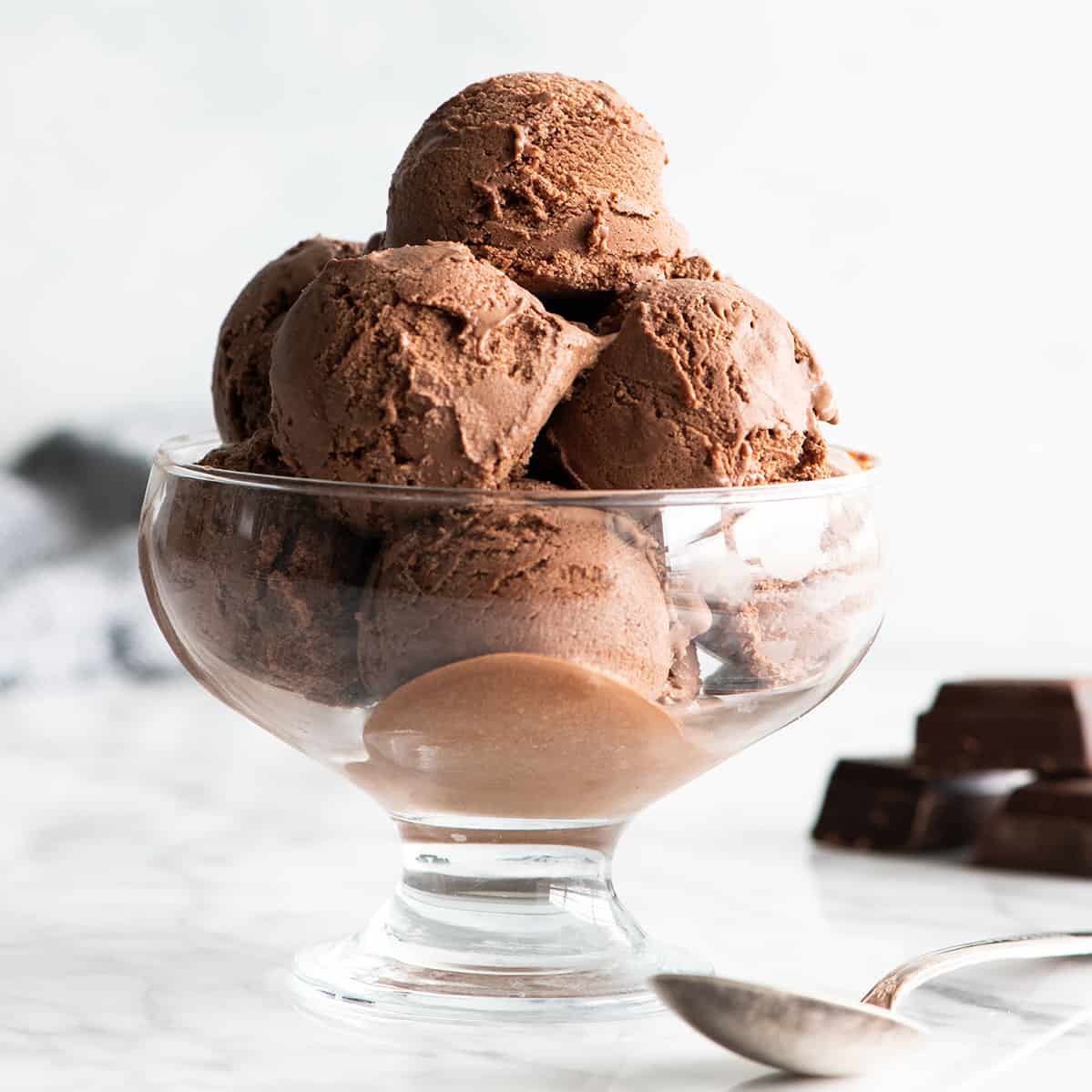 Rich, ultra-creamy, and chocolatey, this is the best homemade chocolate ice cream recipe ever! It's easy to make with only 7 ingredients (including two forms of chocolate), has a rich chocolate flavor, and is just as good as any ice cream shop! Front view of a bowl of chocolate ice cream