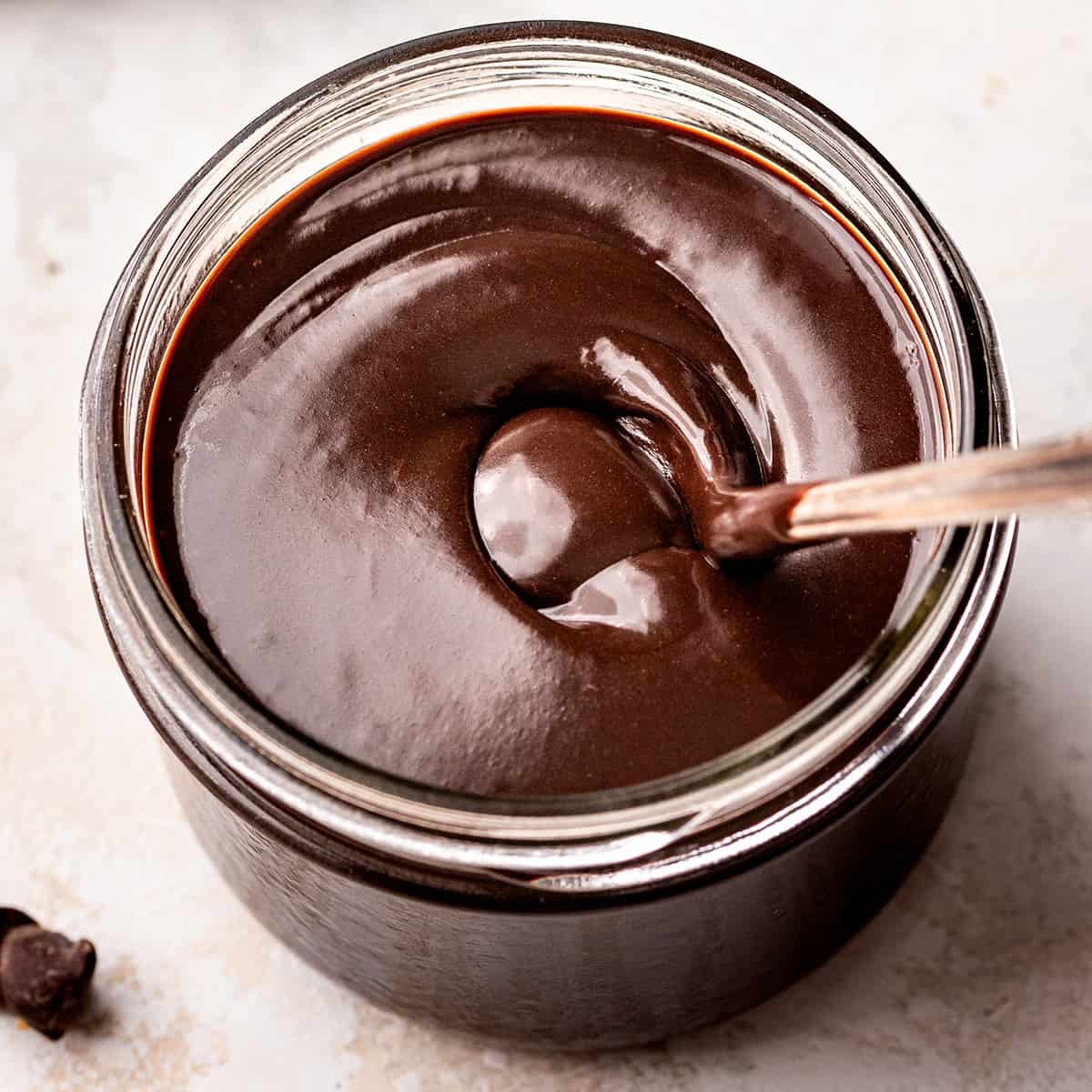 Chocolate Sauce in a glass jar with a spoon