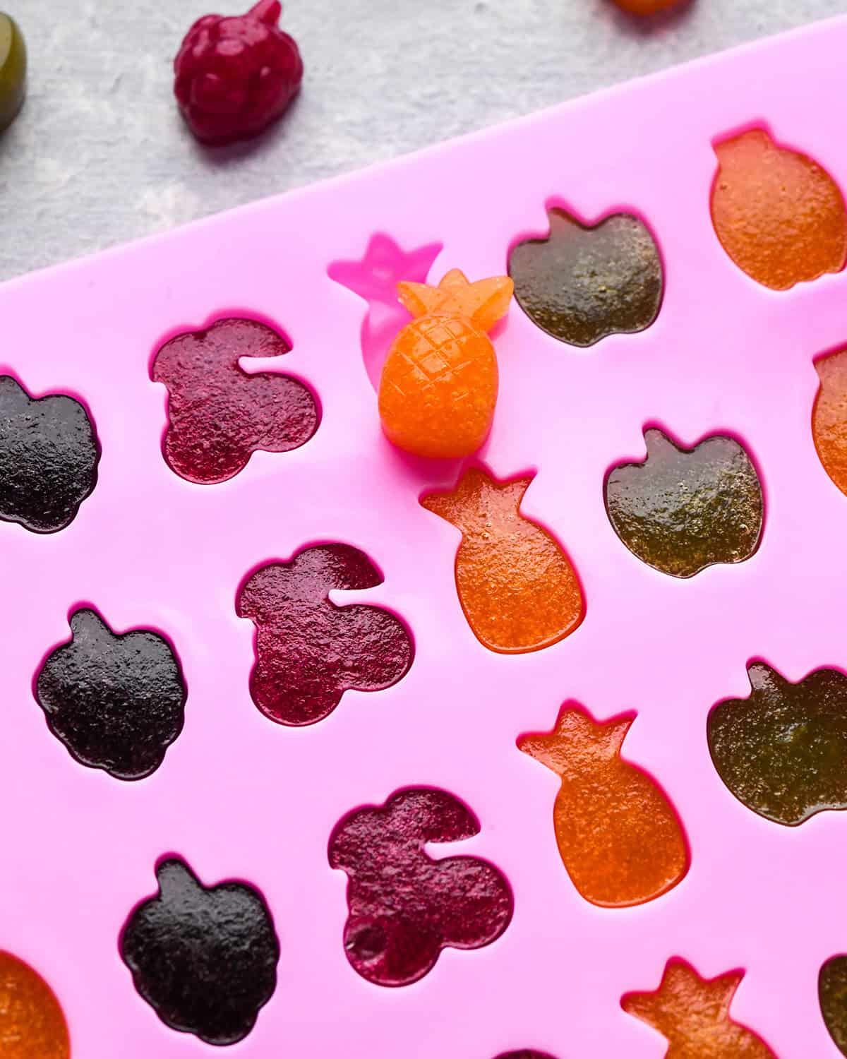 Homemade Fruit Snacks in a mold after chilling - one popped out